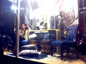 A partygoer takes a breather in an Lillian August window display.
